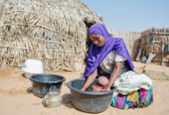A woman bathes her baby at her home in a village near Zinder, Niger.